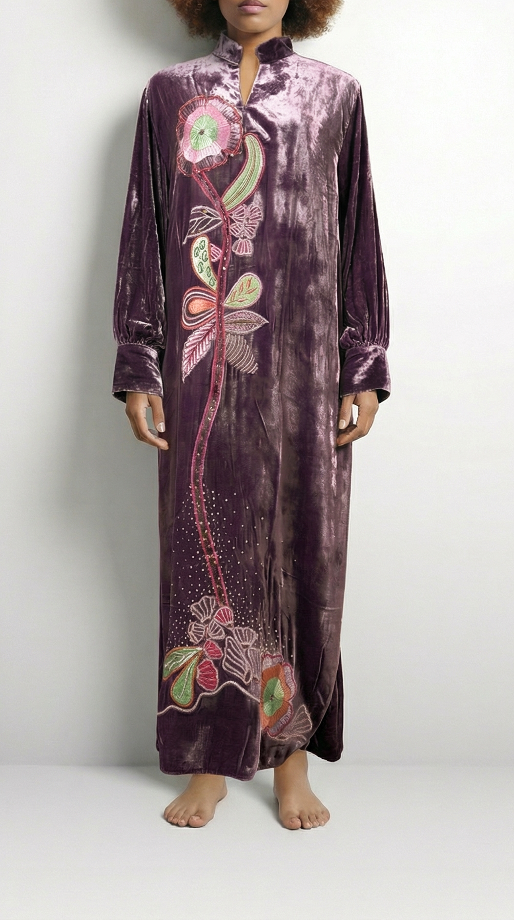 Person wearing a long, patterned dress on a white background