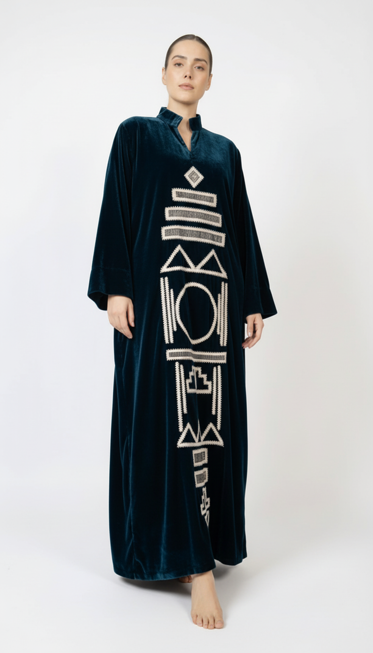 Woman wearing a dark green abaya with white embroidery on a white background