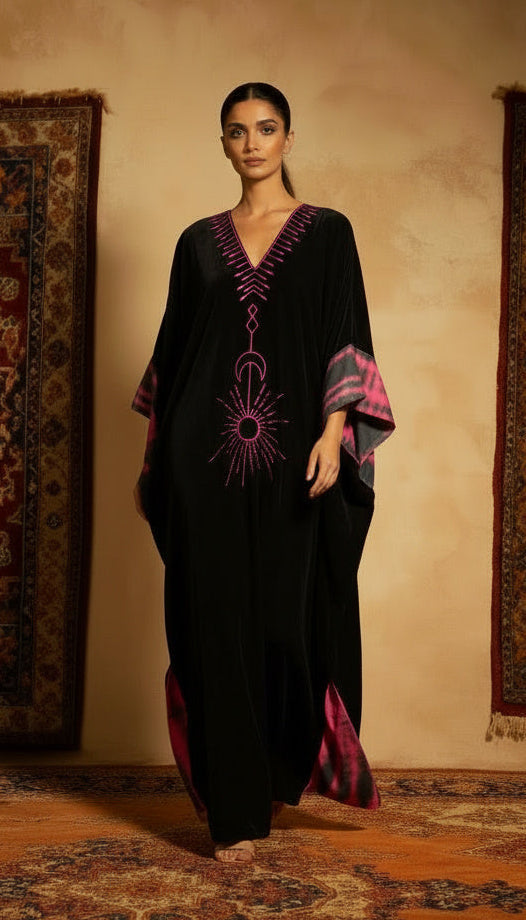 Woman in a black and purple dress standing in front of patterned rugs.