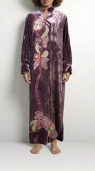 Person wearing a long, patterned dress on a white background